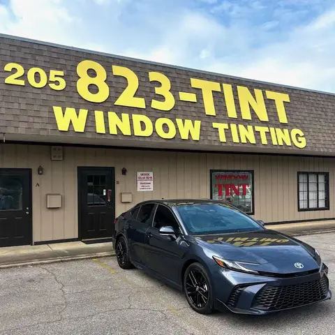 Sedan under the 823-TINT sign, 2026